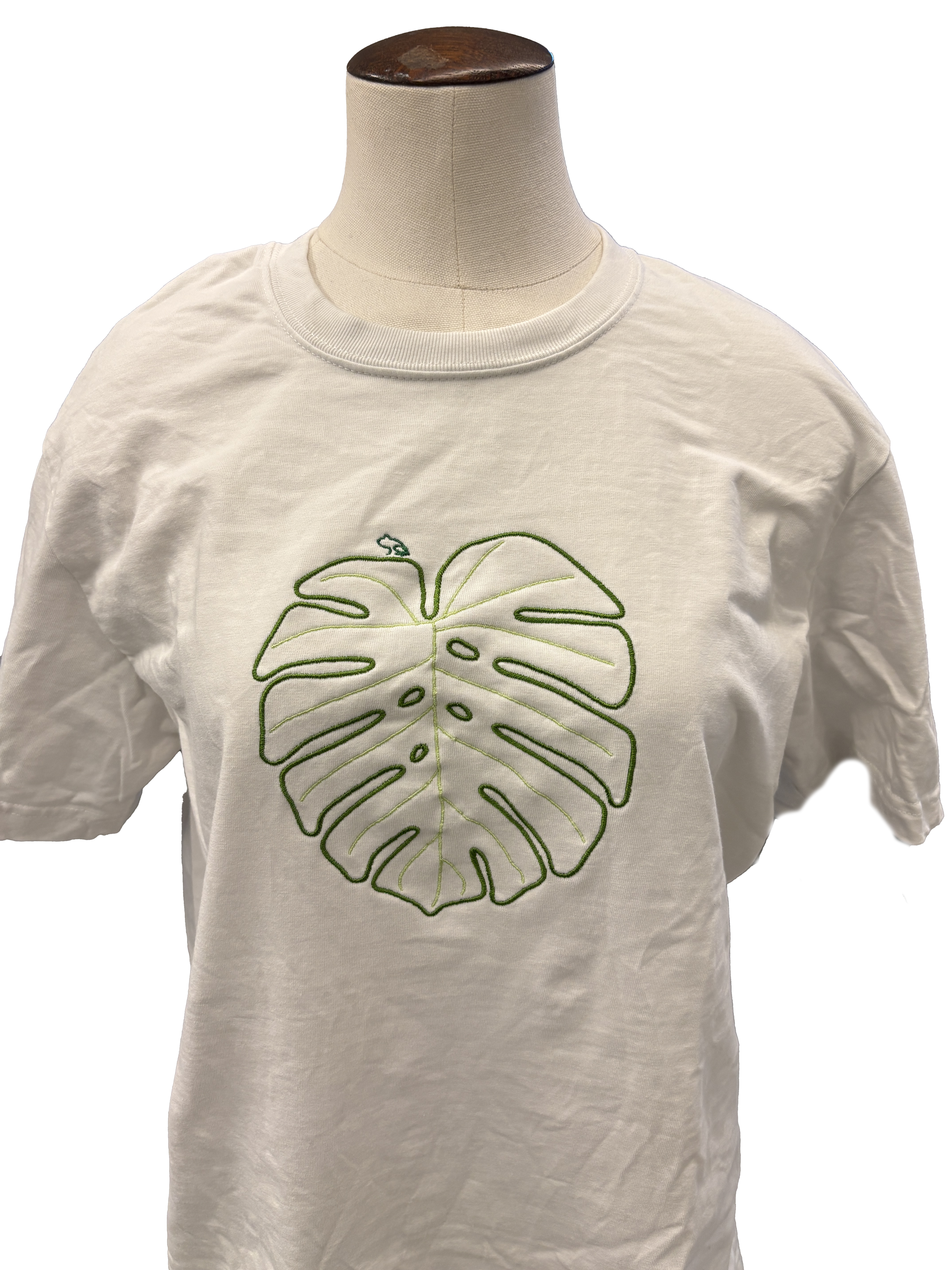 White shirt embroidered with a green monstera leaf